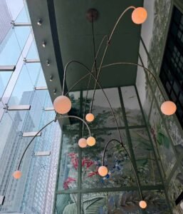Interior light globe chandelier with botanical mural and Chicago skyline through glass windows by Barbara Rozgonyi