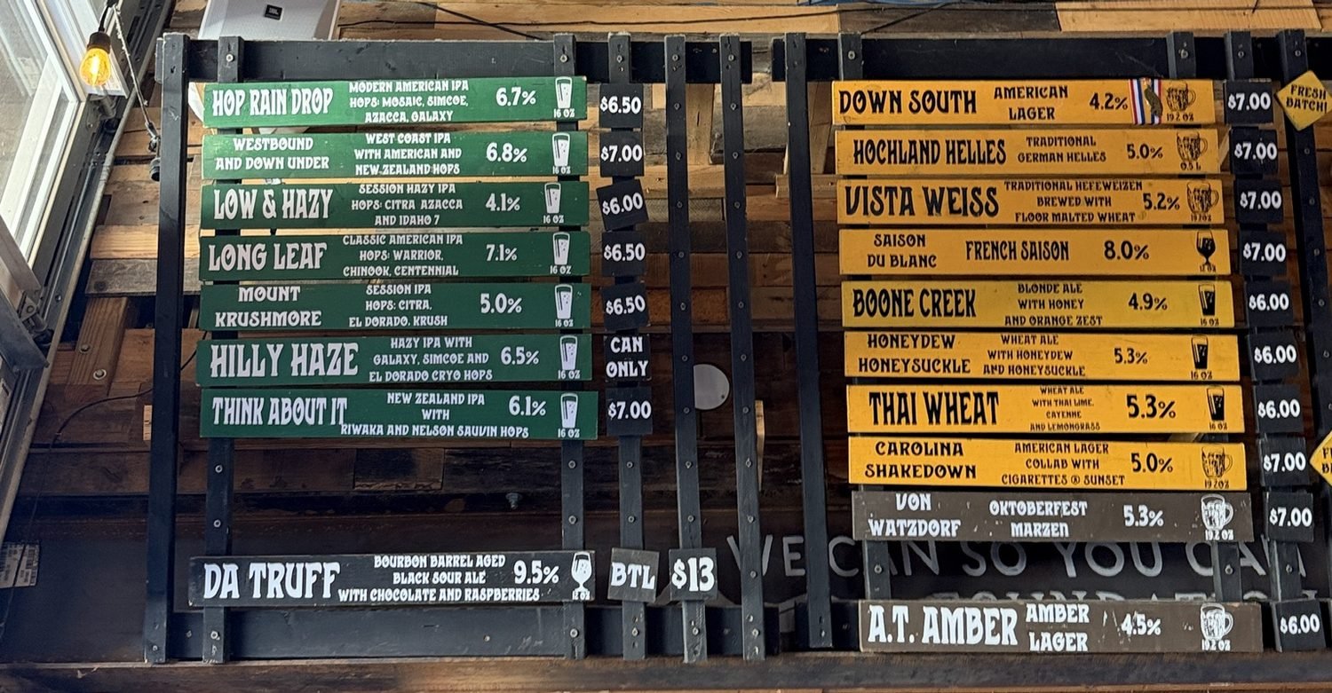 Tap list board at Appalachian Mountain Brewery in Boone, North Carolina, with beer names and prices